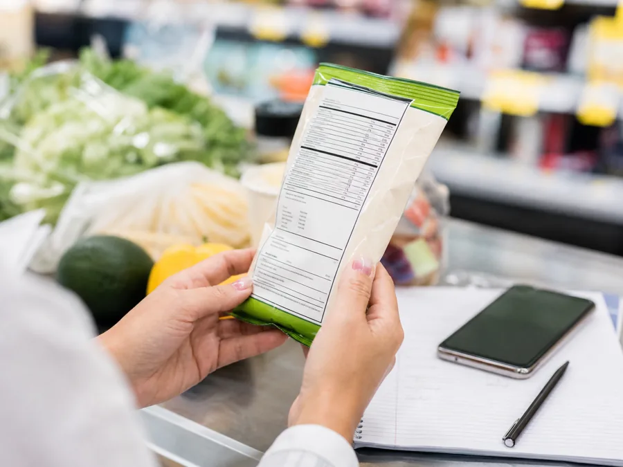 Persona revisando una etiqueta nutricional durante una compra