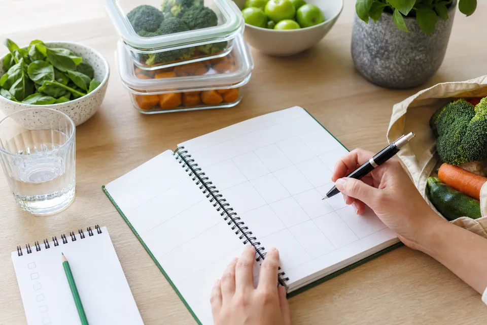 Cuaderno de planificación y alimentos simples sobre una mesa